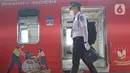 Petugas berjalan di samping Gerbong KAI Commuter bertemakan Kemerdekaan Republik Indonesia ke-76 di Stasiun Kota, Jakarta, Selasa (17/8/2021). Peringatan HUT ke-76 RI tahun 2021, KAI Commuter ikut memeriahkan perayaan tersebut dengan memasang livery khusus. (Liputan6.com/Herman Zakharia)
