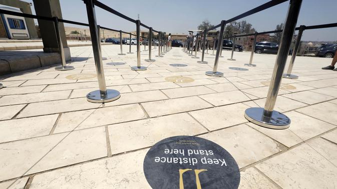 Sebuah penanda mengingatkan warga untuk menjaga jarak di dekat loket pembelian tiket Piramida Giza di Giza, Mesir (1/7/2020). Mesir pada Rabu (1/7) membuka kembali Museum Mesir, Piramida Giza, dan Kuil Luxor untuk kali pertama sejak ditutup akibat COVID-19 pada Maret lalu. (Xinhua/Ahmed Gomaa)