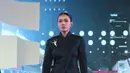 Adinia Wirasti tampil dengan kebaya janggan warna hitam dhiasi bros besar. Dipadukan bawahan kain hitam dengan asken tille dan bordiran keemasan serta sandal slop warna senada. [Adrian/Fimela]