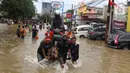 Pengendara sepeda motor melintasi banjir dengan menaiki ojek gerobak di Ciledug, Tangerang, Banten, Kamis (2/1/2020). Jasa ojek gerobak dipatok dengan harga Rp 20 ribu untuk orang dan Rp 50 ribu untuk motor. (Liputan6.com/Angga Yuniar)