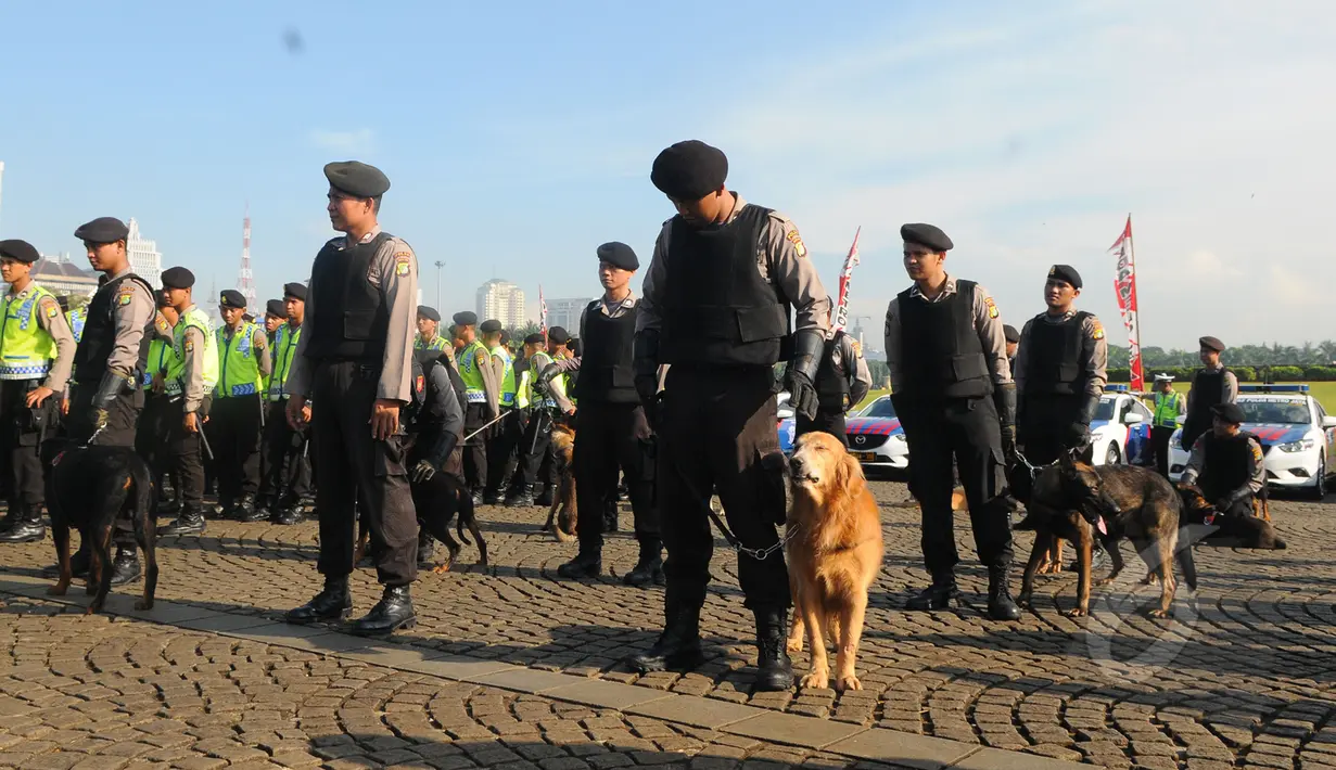 Sejumlah anggota kepolisian membawa anjing pelacak saat apel gelar pasukan di Kawasan Monas, Jakarta,  Rabu (8/4/2015). Polda Metro Jaya menerjunkan 4.236 personel untuk mengamankan pelaksanaan Peringatan KAA. (Liputan6.com/Herman Zakharia)