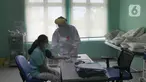 Paramedis melakukan observasi kepada seorang pasien positif COVID-19 yang dirawat di Puskesmas Jurumudi, Tangerang, Banten, Kamis (17/2/2022). Kasus positif COVID-19 di Kota Tangerang terus mengalami penurunan kasus dari 2000 kasus perhari menjadi 1000 kasus perhari. (merdeka.com/Arie Basuki)