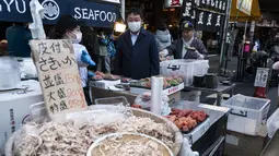 Vendor menjual makanan laut segar dan kering di area "pasar ikan luar" Tsukiji di Tokyo pada 28 Desember 2022. Menjelang liburan Tahun Bar, turis asing dan penduduk lokal berkunjung  ke pasar itu untuk menikmati hidangan bermacam makanan laut. (AFP/Richard A. Brooks)