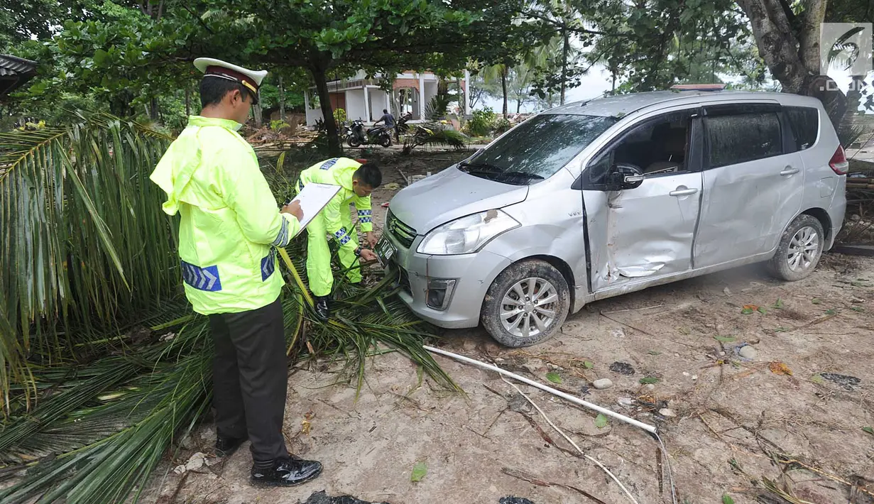 Petugas melakukan identifikasi mobil yang rusak akibat terjangan tsunami di Tanjung Lesung Beach Club, Pandeglang, Banten, selasa (25/12). Indentifikasi dilakukan untuk mencocokan kepemilikan kendaraan dengan para korban tsunami. (Merdeka.com/Arie Basuki)