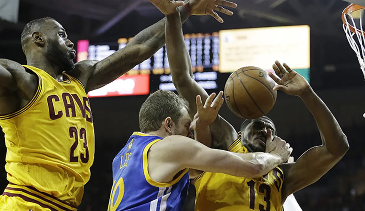 David Lee (10) asal Golden State Warriors dijaga ketat oleh LeBron James (kiri) dan Tristan Thompson dari Cleveland Cavaliers. (AP Photo/Tony Dejak)