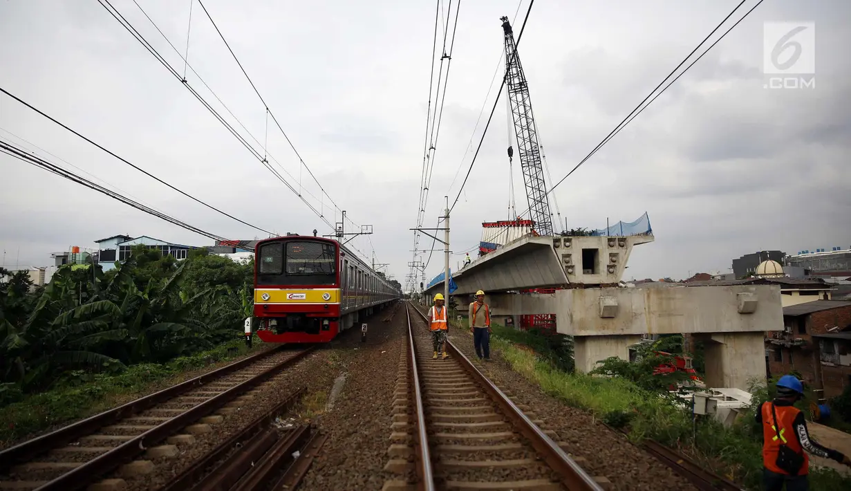 Kereta melintas disamping pembangunan kontruksi jalur DDT di Jakarta, Jumat (13/4). Menhub Budi Karya Sumadi menargetkan penyelesaian pembangunan proyek infrastruktur jalur DDT Manggarai- Cikarang selesai pada 2020. (Liputan6.com/Johan Tallo)