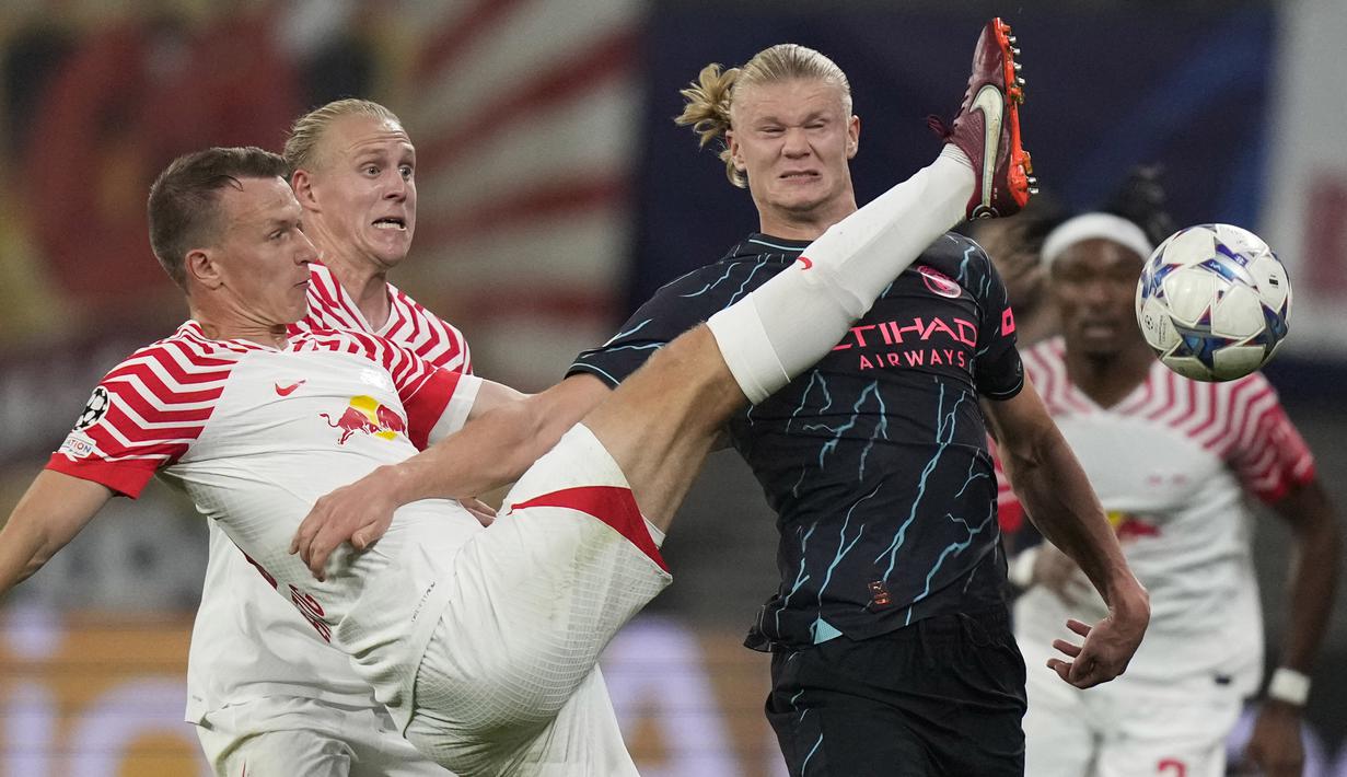 Penyerang Manchester City Erling Haaland berebut bola dengan bek RB Leipzig Lukas Klostermann pada laga matchday 2 Liga Champions 2023/2023 yang digelar di Red Bull Arena Leipzig, Kamis (5/10/2023) dini hari WIB. (AP Photo/Matthias Schrader)