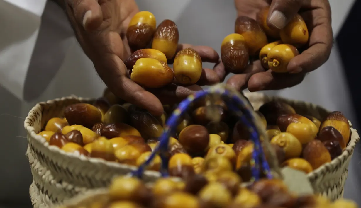 Seorang juri memeriksa buah kurma selama Festival tahunan Kurma Liwa  di kota Liwa, Abu Dhabi pada Rabu (17/7/2019). Festival Kurma Liwa juga menawarkan begitu banyak pengunjung muda untuk belajar, tentang sejarah pohon kurma dan keaslian budaya Arab.  (AP Photo/Kamran Jebreili)