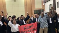Haris Azhar dan Fatia Maulidiyanti meluapkan kegembiraan dengan membentangkan spanduk berlatar merah dan bertuliskan "kami bersama Haris dan Fatia".