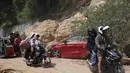 Para pengendara motor melewati lokasi tanah longsor akibat gempa bumi, Provinsi Sarangani, Filipina, Rabu 10 Juni 2026. (AP Photo/Basilio Sepe)