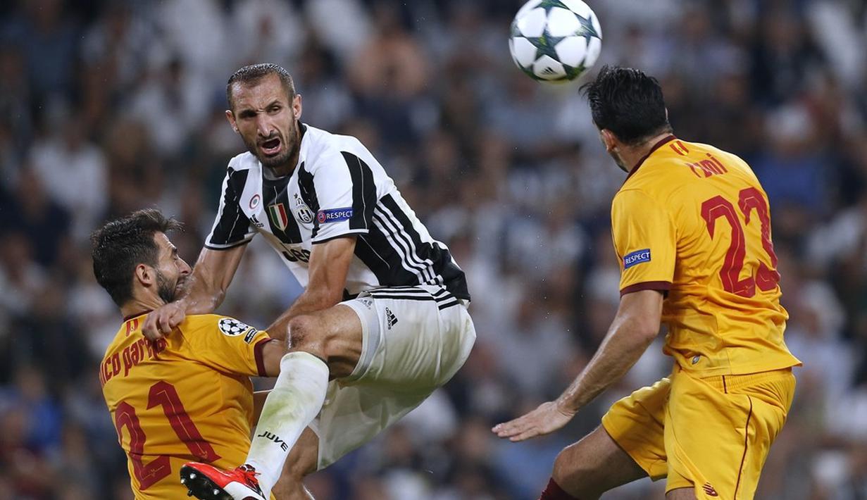 Pemain Juventus, Giorgio Chiellini, berebut bola dengan pemain Sevilla pada laga Liga Champions Grup H di Juventus Stadium, Turin, Kami (15/9/2016) dini hari WIB. (AFP/Marco Bertorello)