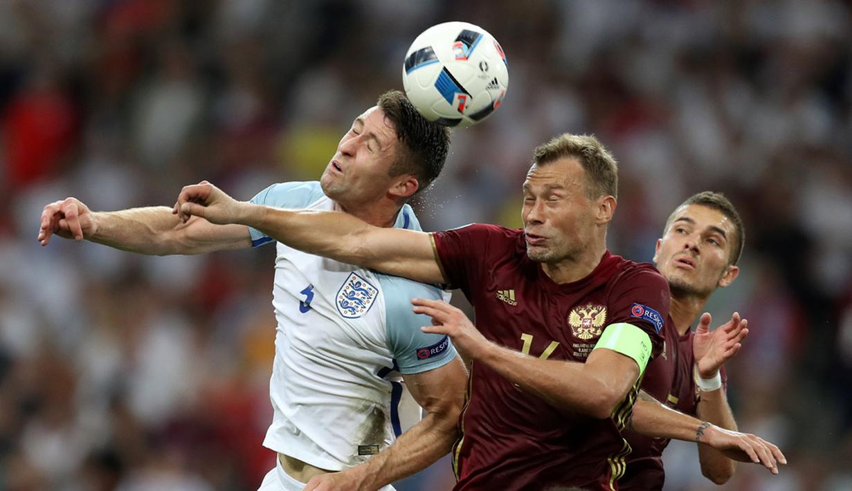 Pemain Inggris, Gary Cahill, duel dengan pemain Rusia, Vasily Berezutskiy, pada laga Grup B Piala Eropa 2016 di Stade Velodrome, Marseille, Minggu (12/6/2016) dini hari WIB. (AFP/Valery Hache)
