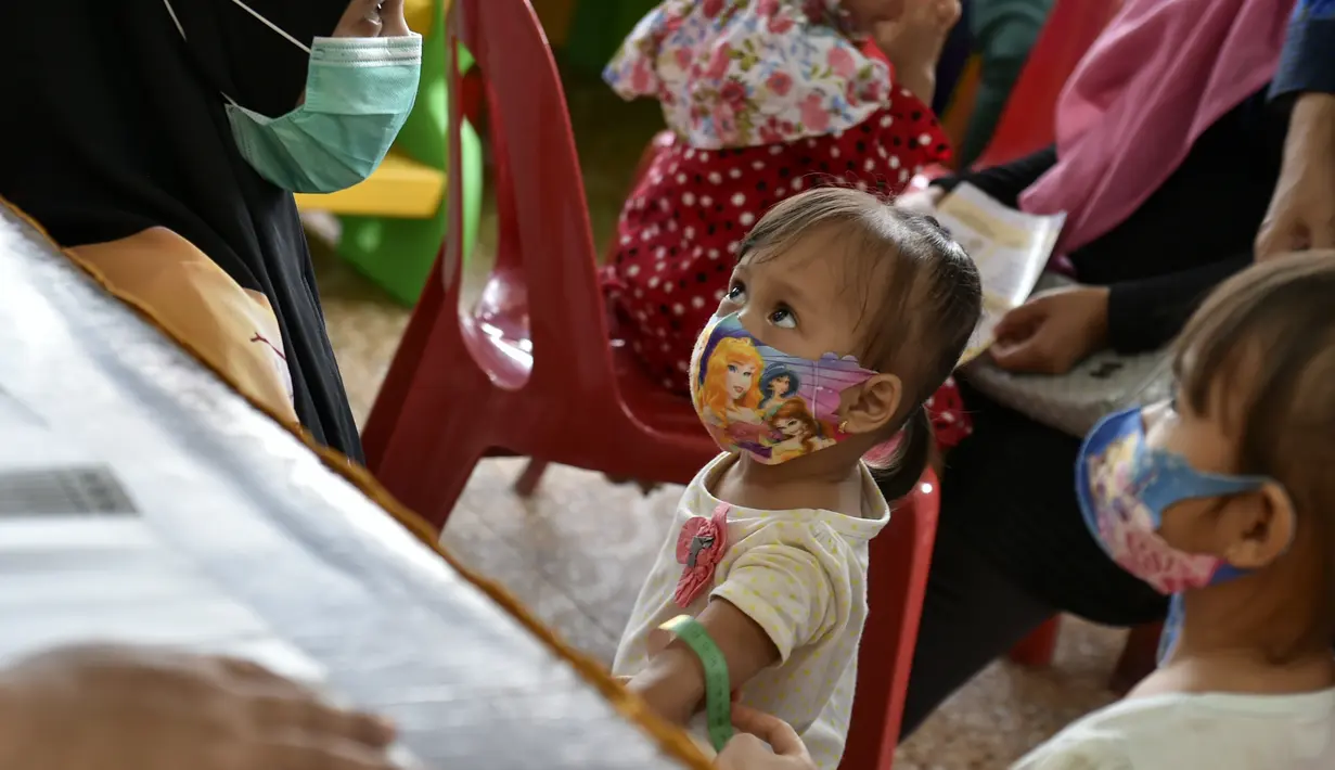 Seorang anak diukur tumbuh kembangnya sebelum menerima vaksin campak dan polio di sebuah posyandu di Banda Aceh, Aceh, Rabu (4/10/2020). Pemberian vaksin polio dan vaksin campak secara gratis yang berlanjut di tengah pandemi COVID-19 bertujuan memperkuat imunitas anak. (CHAIDEER MAHYUDDIN / AFP)