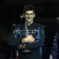 Petenis Serbia, Novak Djokovic memegang trofi AS Terbuka setelah mengalahkan Juan Martin del Potro pada partai final di New York, Minggu (9/9). Gelar ini adalah yang keempat di AS Terbuka sejak yang terakhir pada 2015. (MATTHEW STOCKMAN/GETTY IMAGES/ AFP)