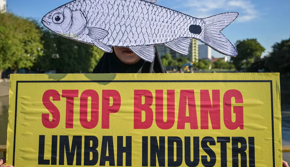 Seorang aktivis dari Ecoton (Ecological Observation and Wetlands Conservation) yang mengenakan masker ikan mengikuti unjuk rasa menyerukan sungai bersih bebas sampah dan limbah industri, serta perlindungan ikan sungai, sebagai bagian dari perayaan Hari Lingkungan Hidup Sedunia di Surabaya, Jawa Timur, Jumat 5 Juni 2026. (JUNI KRISWANTO/AFP)