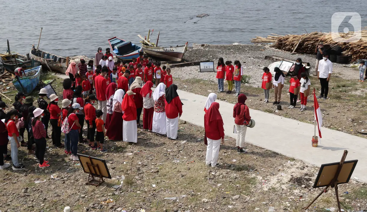 Suasana Upacara Peringatan HUT RI ke-77 di Kawasan Kalibaru Barat, Cilincing, Jakarta, Rabu (17/8/2022). Memperingati Hari Kemerdekaan Indonesia ke-77, anak-anak yang tergabung dalam Kelas Jurnalis Cilik bersama para relawan melaksanakan upacara bendera dan beragam lomba. (Liputan6.com/Helmi Fithriansyah)