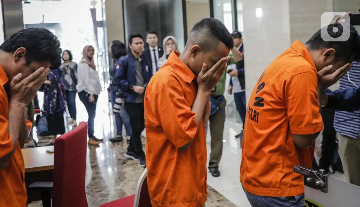 Tersangka dihadirkan saat rilis kasus penangkapan pelaku hacker Indonesia di Bareskrim Polri, Jakarta, Jumat (24/1/2020). Bareskrim menangkap tiga tersangka hacker yang menginfeksi ratusan perusahaan E-Commerce Luar Negeri menggunakan virus Malware JS Sniffer. (Liputan6.com/Faizal Fanani)
