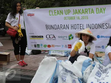 Para relawan saat merapikan kantong - kantong sampah selama acara Clean Up Jakarta Day di Bunderan Hotel Indonesia, Jakarta, minggu (18/10/2015). Sebanyak 15.000 relawan mengikuti kegiatan Clean Up Jakarta Day 2015. (LIputan6.com/Herman Zakharia)