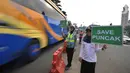 Petugas kepolisian dan Badan Pengelola Transportasi Jabodetabek (BPTJ) berdiri sambil membawa papan imbauan saat uji coba sistem kanalisasi 2-1 Jalur Puncak di kawasan Gadog, Bogor, Jawa Barat, Minggu (27/10/2019). (merdeka.com/Arie Basuki)