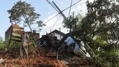 Seorang warga membawa tempat tidur kayu yang dibongkar setelah tanah longsor akibat hujan lebat di Belo Horizonte, Brasil (27/1/2020). Lebih dari 30.000 orang terlantar akibat hujan lebat di Brasil tenggara yang juga menewaskan lebih dari 50 orang. (AP Photo/Gustavo Andrade)
