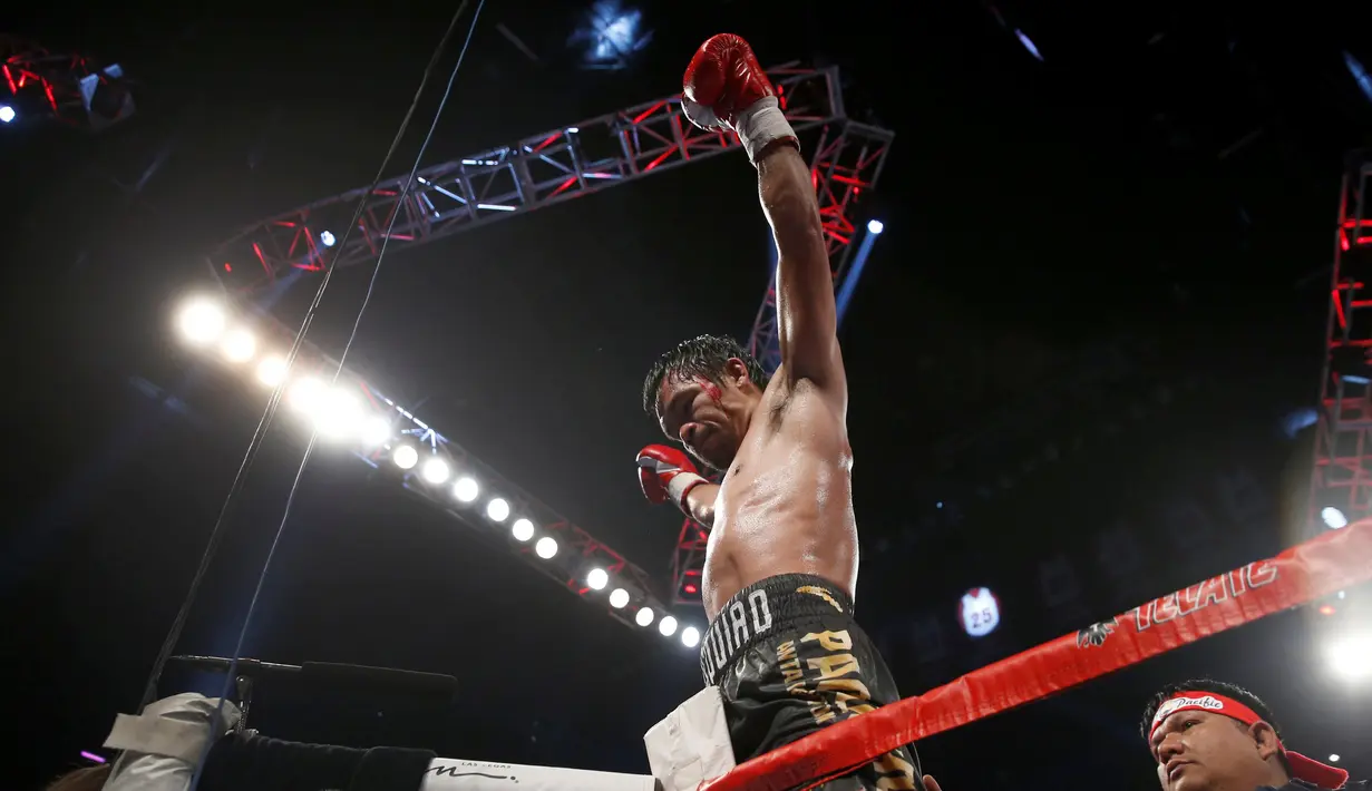 Manny Pacquiao merayakan kemenangan atas Jessie Vargas dalam perebutan sabuk WBO kelas Welter di Las Vegas, AS (5/11). Pacquiao menorehkan rekor sebagai senator pertama yang bisa menjadi juara dunia tinju. (Reuters/Steve Marcus)