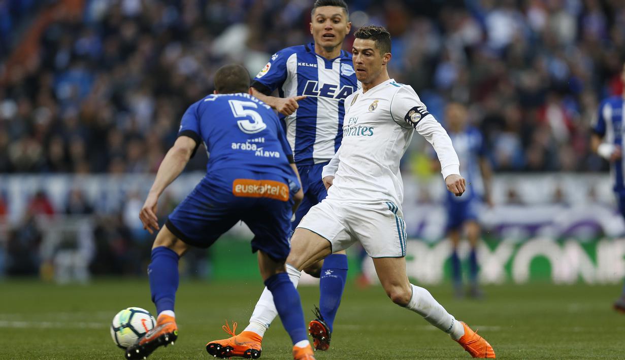 Cristiano Ronaldo (kanan) saat mengecoh dua pemain Alaves pada La Liga Santander di Santiago Bernabeu stadium, Madrid, (24/2/2018). Real Madrid menang 4-0. (AP/Francisco Seco)