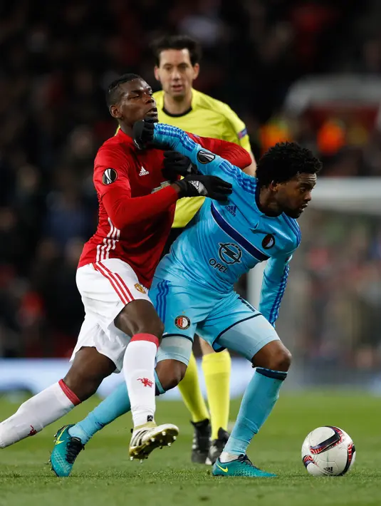 Bek Feyenoord, Miquel Nelom berusaha membawa bola dari kawalan gelandang MU, Paul Pogba pada pertindangan Grup A Liga Europa di Stadion Old Trafford, Inggris (24/11). MU menang telak atas Feyenoord dengan skor 4-0. (Reuters/Carl Recine)