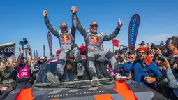 Pembalap Team Audi Sport, Carlos Sainz (kanan) dan co-driver, Lucas Cruzof merayakan kemenangan setelah menyelesaikan etape terakhir Reli Dakar 2024 di Yanbu, Arab Saudi, Jumat, 19 Januari 2024 waktu setempat. (AFP/Patrick Hertzog)