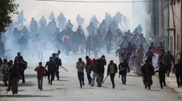 Ratusan petani daun koka membubarkan diri saat polisi melepaskan gas air mata di La Paz, Bolivia, Selasa (21/2). Mereka protes kebijakan baru Presiden Evo Morales terkait petani daun koka. (AP Photo / Juan Karita)