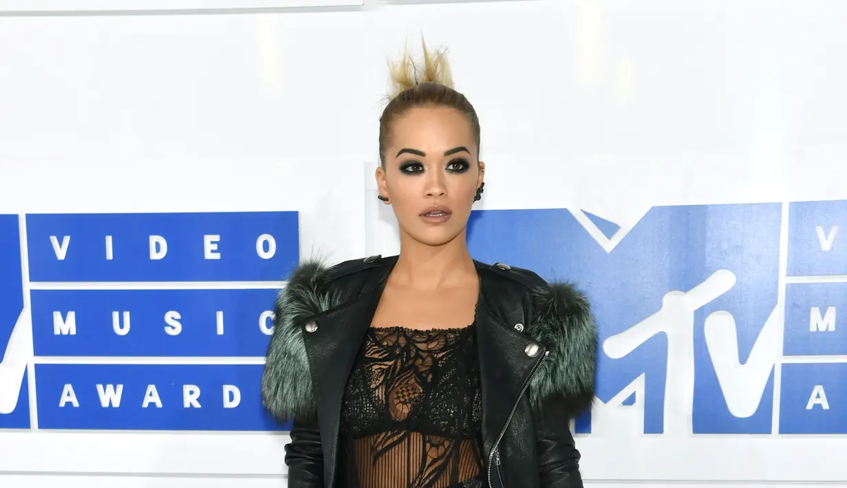 Rita Ora hadir dengan mengenakan busana rancangan dari Marc Jacobs. Gaun menerawang warna hitam yang dipadukan sedikit bulu-bulu di lengan dan bawah. Terlihat rambutnya dikuncir rapi ke belakang. (AFP / JAMIE MCCARTHY / GETTY IMAGES NORTH AMERICA)