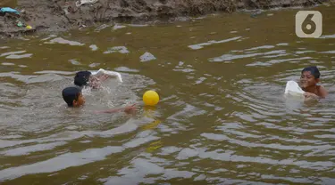 Anak-anak bermain di aliran Kali Ciliwung, Kampung Pulo, Jakarta, Jumat (2/12/2022). Anak-anak tetap bermain di sungai walaupun membahayakan keselamatan tanpa pengawasan orangtua, di mana dalam sepekan terakhir ini Jakarta diguyur hujan dengan intensitas curah hujan tinggi. (merdeka.com/Imam Buhori)