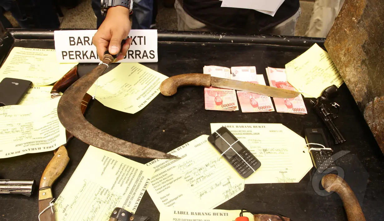 Barang bukti dua pistol mainan, empat telepon seluler, empat golok, sebilah celurit dan uang tunai Rp 2,2 juta ditunjukkan pihak kepolisian, Jakarta, Selasa (17/3/2015).(Liputan6.com/Johan Tallo)