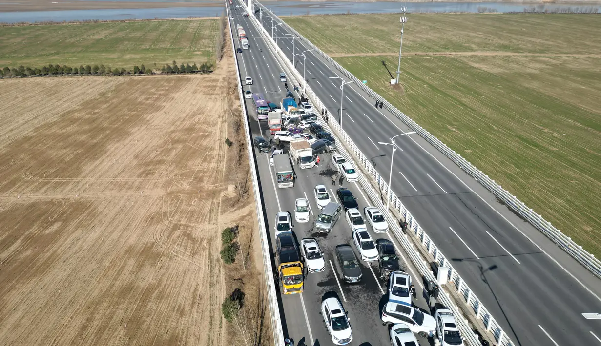 Foto udara menunjukkan tabrakan beberapa kendaraan di Jembatan Sungai Kuning Zhengxin di Zhengzhou, di provinsi Henan tengah China pada 28 Desember 2022. Banyak orang terluka dan terjebak di lokasi kecelakaan dan pemadam kebakaran sudah berada di jembatan itu. (AFP/STR)