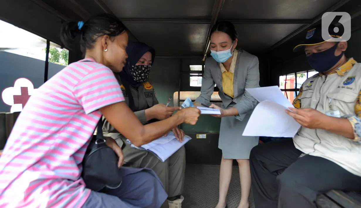 Petugas melakukan denda terhadap warga yang tidak mengenakan masker di kawasan Jalan Ir. H. Juanda, Depok, Jawa Barat, Kamis (23/7/2020). Sejumlah pengendara dan penumpang angkutan umum terjaring razia Gugus Tugas Percepatan Penanganan COVID-19 Kota Depok. (merdeka.com/Arie Basuki)