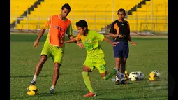Pemain asing Persebaya asal Brasil, Otavio Dutra (kiri) mengecoh rekan setimnya saat latihan di Stadion H Agus Salim, Padang, Jumat (16/1/2015). Persebaya akan berhadapan dengan Semen Padang di laga perdana SCM Cup 2015 grup A. (Liputan6.com/Johan Tallo)