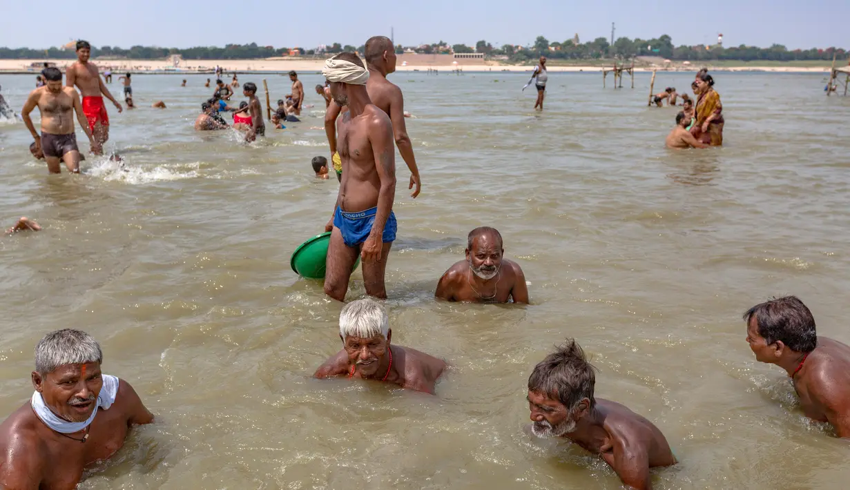 Orang-orang mencari uang yang dilemparkan oleh umat Hindu di Sungai Gangga, sebagai bagian dari ibadah selama festival Gangga Dussehra, di Prayagraj, India (1/6/2020). (AP Photo/Rajesh Kumar Singh)