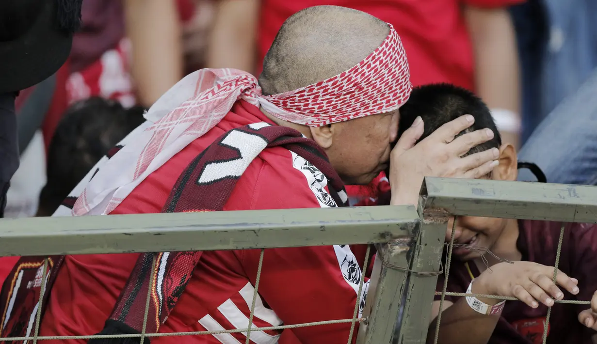 Pentolan suporter PSM Makassar, Daeng Uki, berusaha menenangkan anaknya yang menangis saat PSM Makassar takluk dari Persija Jakarta pada laga final Piala Indonesia di SUGBK, Minggu (21/7). Persija menang 1-0 atas PSM.  (Bola.com/M Iqbal Ichsan)