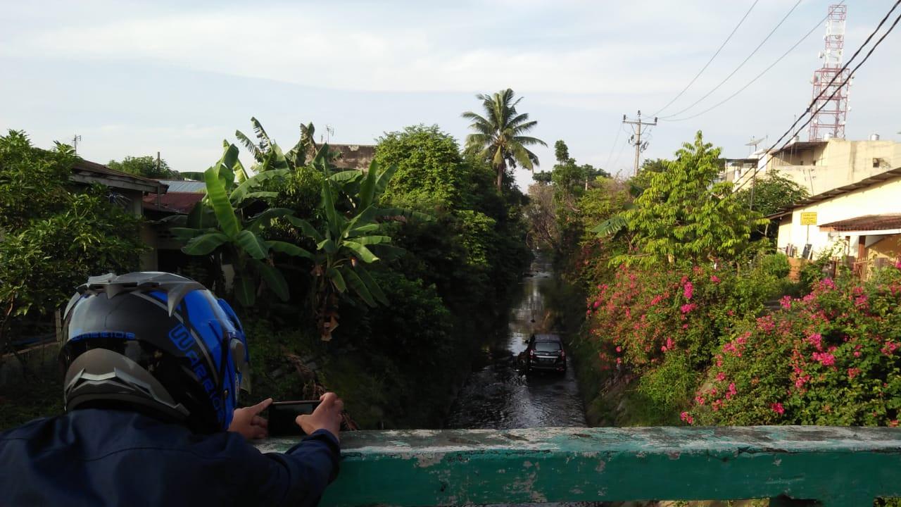 Mobil Parkir di Tengah Parit Curi Perhatian Warga Medan
