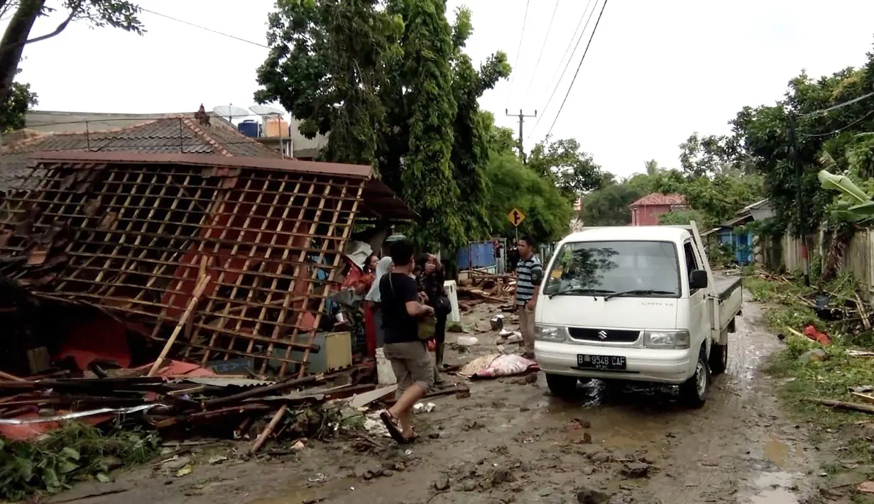 Warga memeriksa kerusakan rumah mereka setelah tsunami menerjang Pantai Carita, di perairan Banten, Minggu (23/12). Tsunami menerjang pantai di Selat Sunda, khususnya di daerah Pandenglang, Lampung Selatan, dan Serang. (SEMI / AFP)
