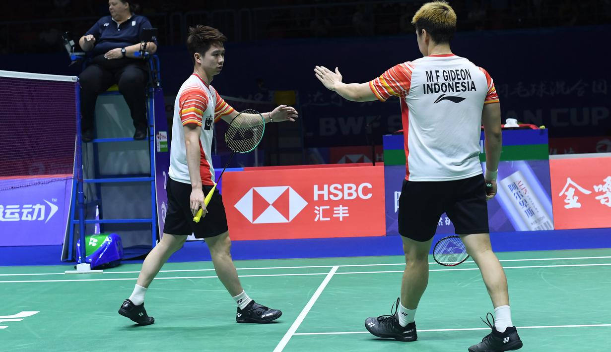 Ganda putra Indonesia, Marcus Gideon (kanan) dan Kevin Sanjaya berselebrasi usai memenangkan satu poin atas Lee Yang dan Wang Chi-Lin (Chinese Taipei) pada babak perempat final Piala Sudirman 2019 di Nanning, China, Jumat (24/5/2019). Kevin/Marcus menang dua gim langsung 21-17, 21-17 (WANG ZHAO/AFP)