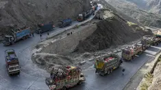 Truk-truk yang mengangkut para pengungsi Afghanistan beserta barang-barang mereka terlihat di sepanjang jalan menuju perbatasan Torkham Pakistan-Afghanistan pada tanggal 3 November 2023. (Abdul MAJEED/AFP)