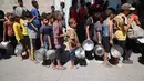 Dua tahun sejak perang Israel–Hamas pecah pada 7 Oktober 2023, Jalur Gaza kini menghadapi krisis kemanusiaan terburuk dalam sejarah modern. Tampak dalam foto, anak-anak pengungsi Palestina mengantre untuk menerima makanan hangat dari dapur amal di kamp pengungsi Nuseirat di Jalur Gaza yang dikepung Israel pada 11 September 2025, di tengah bencana kelaparan yang dinyatakan PBB setelah hampir dua tahun perang. (Eyad BABA/AFP)