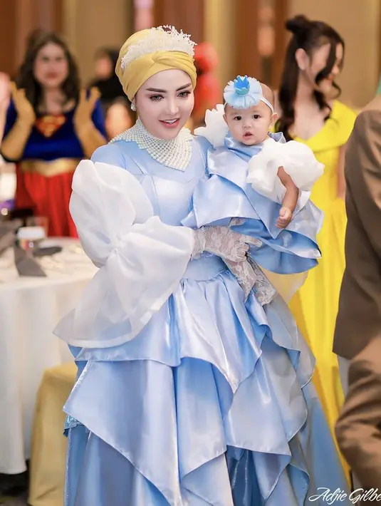 Tampilannya pun serasi dengan putri keduanya yang sama-sama mengenakan gaun biru lengan putih, ditambah dengan bando birunya. [@bellashofie_rigan]