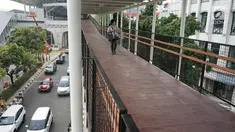 Warga melintasi jembatan penyeberangan (Skybridge) yang menghubungkan Stasiun LRT Velodrome dengan Halte Transjakarta Pemuda di Rawamangun, Jakarta, Senin (29/7/2019). Skybridge ini bertujuan memudahkan integrasi penumpang LRT menuju Transjakarta atau sebaliknya. (Liputan6.com/Immanuel Antonius)