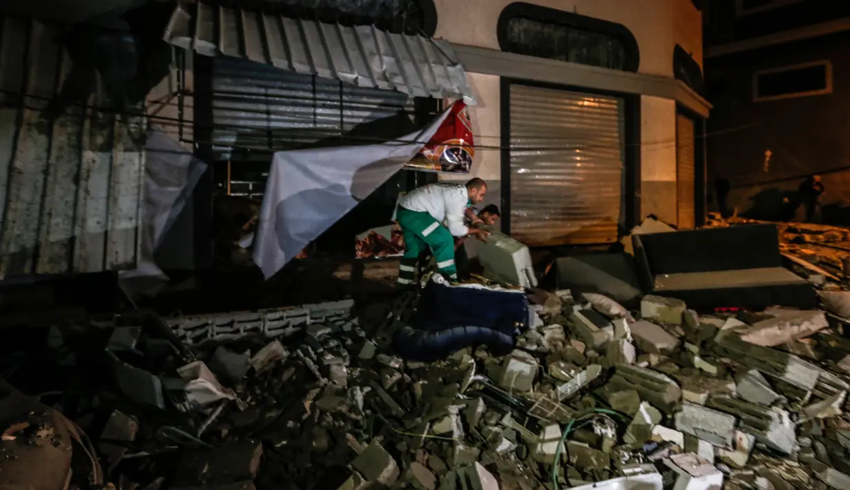 Warga memeriksa rumah komandan Jihad Islam Baha Abu Al-Ata setelah serangan rudal Israel di Kota Gaza, Palestina, Selasa (12/11/2019). Kementerian Kesehatan di Gaza membenarkan bahwa dua orang tewas dalam serangan itu. (MAHMUD HAMS/AFP)