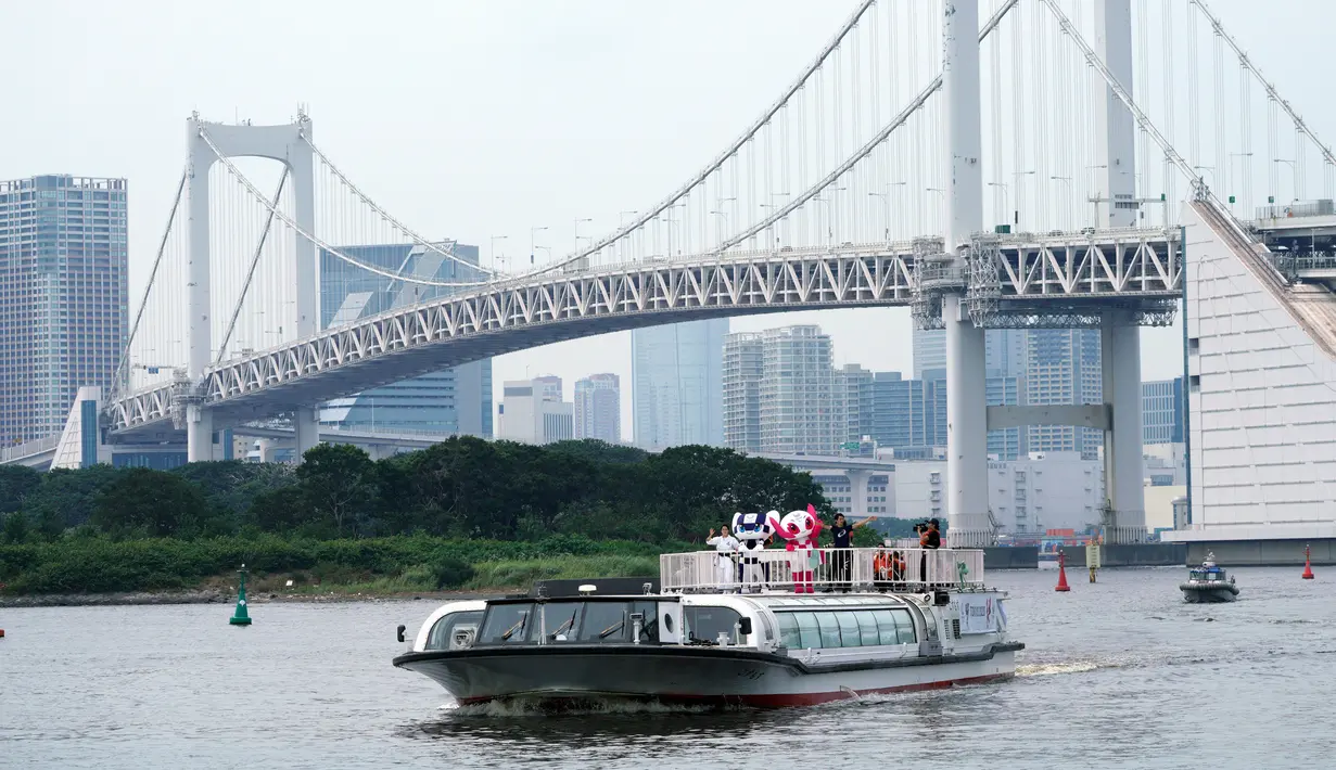 Maskot Olimpiade dan Paralimpik Tokyo 2020, Miraitowa dan Someity menyapa warga dari atas kapal saat mereka menyusuri Rainbow Bridge dalam debut mereka di Tokyo, Jepang, Minggu (22/7). (AP Photo/Eugene Hoshiko)