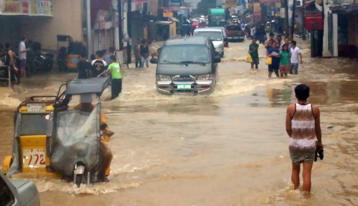 Banjir terjadi akibat hujan deras yang dibawa oleh Topan Goni di Kota Condon, Ilocos sur, Filipina, Senin (24/8/2015). Topan yang membawa angin berkecepatan 140 km/jam hingga 195 km/jam tersebut diperkirakan akan menerjang Okinawa, Jepang. (AFP Photo)