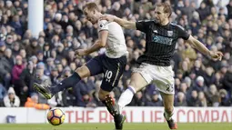Pemain Tottenham Hotspur, Harry Kane (kiri) melepaskan tembakan saat dihadang pemain West Brom, Craig Dawson pada laga Premier League di White Hart Lane stadium, London, (14/1/2017).  (AP/Matt Dunham)