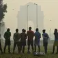 Sejumlah pria mendengarkan pelatih sebelum bermain sepak bola di tengah kondisi kabut asap tebal di New Delhi, India (30/10). Tingkat kabut melonjak selama musim dingin di Delhi, ketika kualitas udara memburuk. (AFP Photo/Prakash Singh)