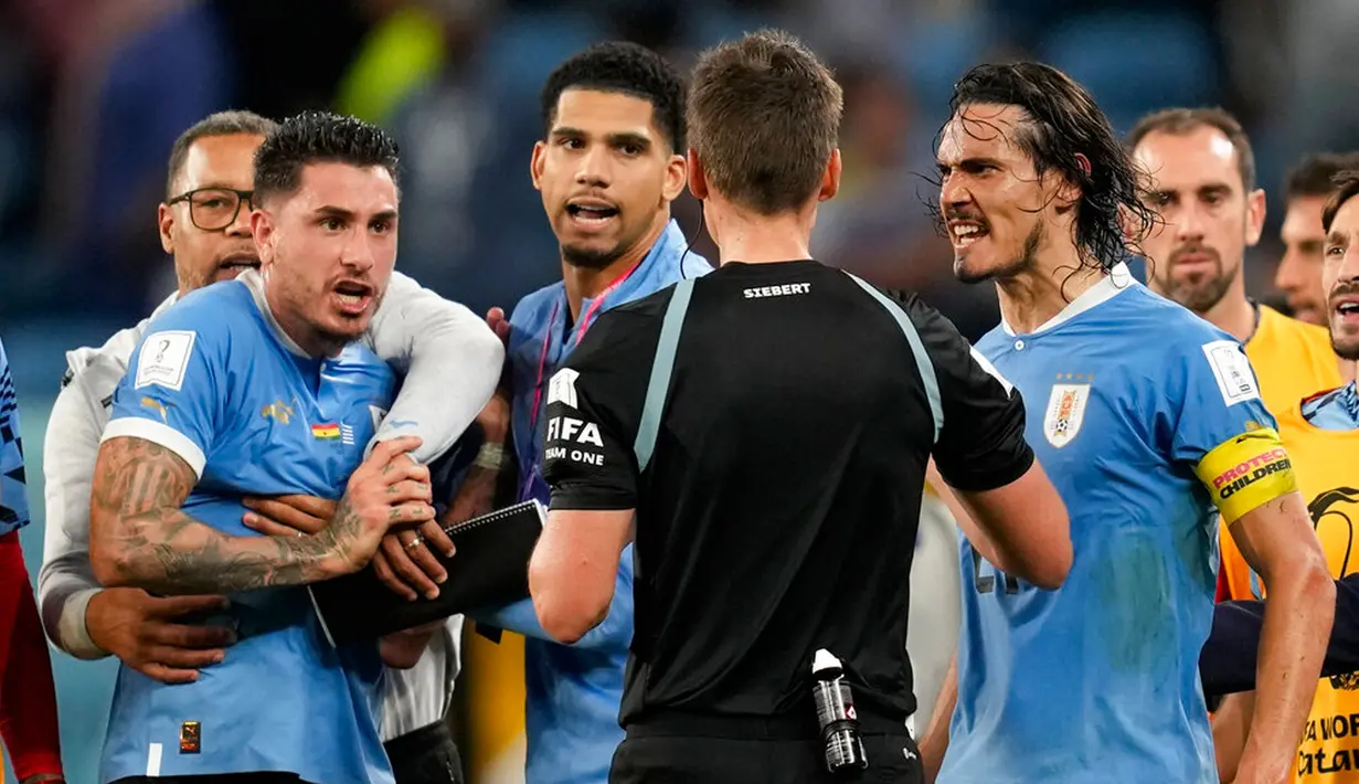 Pemain Uruguay Edinson Cavani berselisih dengan wasit Daniel Siebert setelah dia menerima kartu kuning pada akhir pertandingan sepak bola Grup H Piala Dunia 2022 melawan Ghana di Stadion Al Janoub, Al Wakrah, Qatar, 2 Desember 2022. Uruguay mengalahkan Ghana 2-0, namun tetap tak lolos ke babak 16 besar Piala Dunia 2022. (AP Photo/Darko Vojinovic)